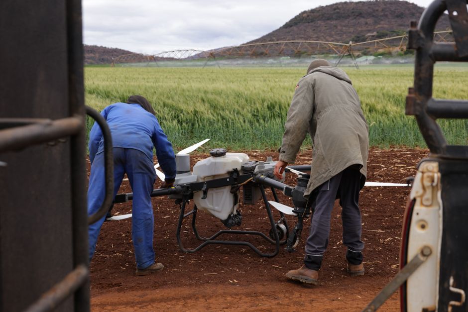 A drone capturing aerial images for photogrammetry in a commercial construction site.